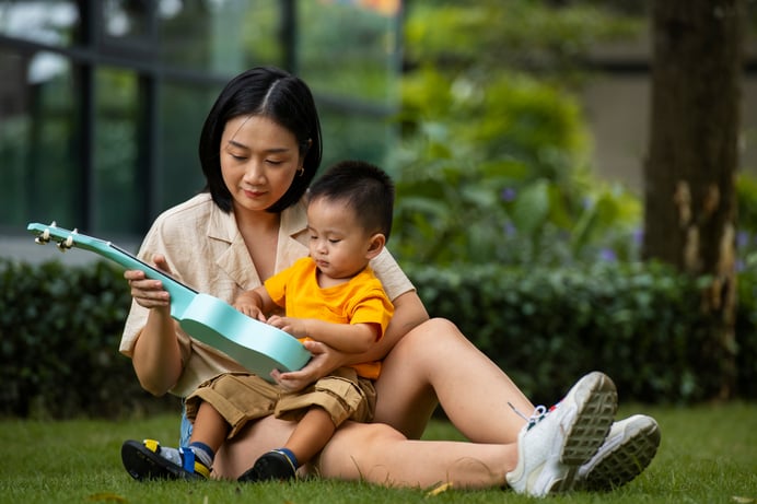 mother-kid-sitting-grass-full-shot